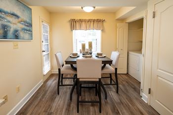 A dining room with a table set for four.